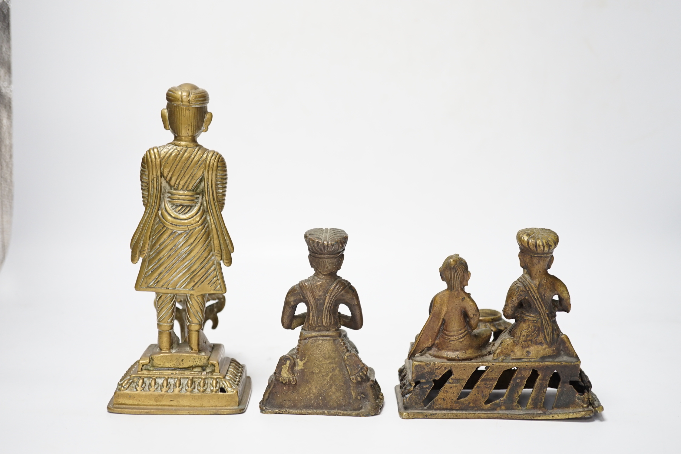 Three Nepalese figural brass oil lamps, 18th/19th century